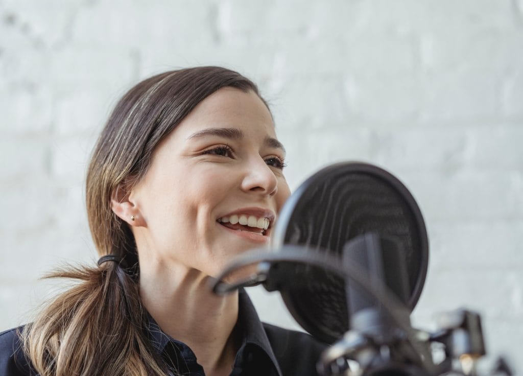 Young woman speaking into a microphone